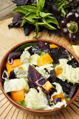 Delicious salad with Chinese cabbage, tomato and basil served on wooden table, above view