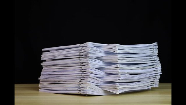 stack of paper documents with clip on a wooden table. Corporate business financial data management concept. Organize Documents &ndash; 4K Stop Motion, Stack Files Overload 