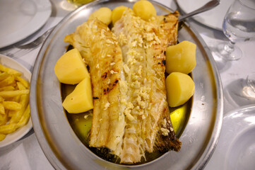 Grilled fillet of white codfish served with potatos in fish restaurant in Portugal