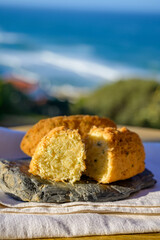 Codfish croquette pastais de bacalhau, traditional portuguese snack food served outdoor with view on blue Atlantic ocean near Sintra in Lisbon area, Portugal
