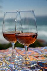 Tasting of sweet moscatel de setubal or porto portuguese wine and view on blue Atlantic ocean near Sintra in Lisbon area, Portugal