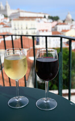 Drinking of red and white Portuguese wine in outdoor cafe at view point on old part of Lisbon city, Portugal