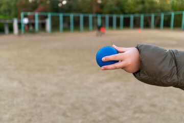 野球の持ち方と投げ方を練習している子供の手。公園、小学生、キャッチボール、初心者。秋。