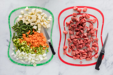 Chopped beef stew ingredients on different mats to prevent cross contamination.