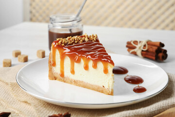 Tasty cheesecake with caramel and nuts served on table