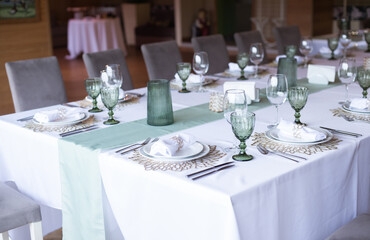 
Serving and decoration of the wedding table. Glasses, spoons, forks and white napkins
