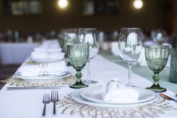 
Serving and decoration of the wedding table. Glasses, spoons, forks and white napkins