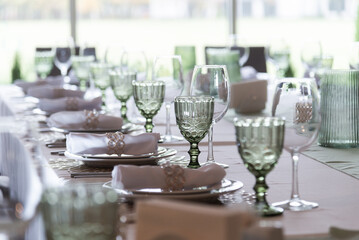 
Serving and decoration of the wedding table. Glasses, spoons, forks and white napkins