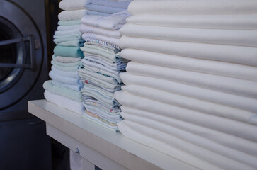 Stack of  freshly ironed sheets or fabrics in an industrial laundry.