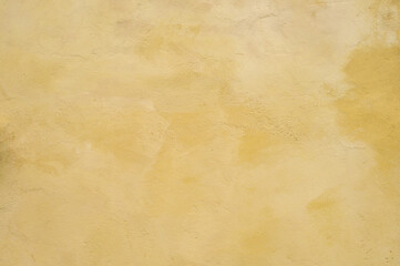 Textured wall in shades of yellow paint, as a graphic background
