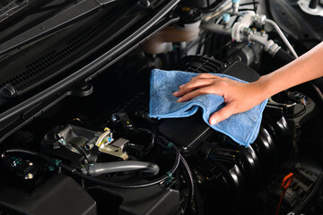 hand of a man holding a blue cloth caring, maintenance car and cleaning And engine car room.Hand focus selection