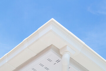 Drainage System rain with white vinyl gutter modern style in new home on blue sky background. © Pannarai