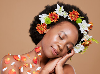Flower, crown and black woman relax in studio for beauty, skincare and plant product on brown...