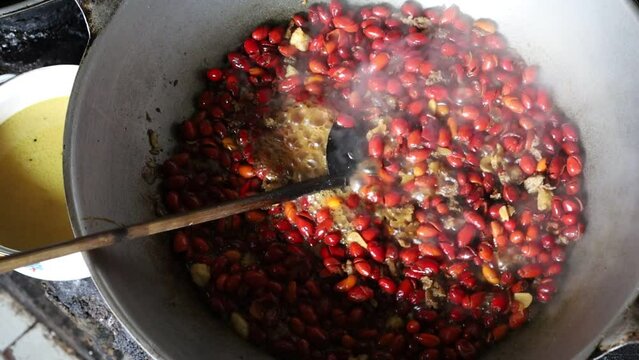 Top view of cooking melinjo skin or red gnetum gnemon fruit. Indonesian traditional food.