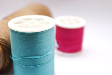 Green, red, brown spools placed on a white background.