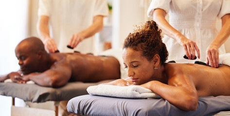Couple massage, rock or spa therapist for relax, luxury or wellness treatment for health, self care or zen at resort. Healthcare, beauty salon or black woman and man for healthy, skincare or therapy