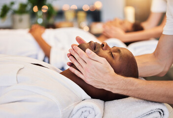 Face massage, beauty therapist and black man, skincare and relax in luxury spa with zen, hands and rest on a bed. Wellness, skin health and cosmetic treatment for healthy skin and relaxing body