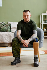 Full length portrait of military veteran with prosthetic leg wearing army uniform - obrazy, fototapety, plakaty