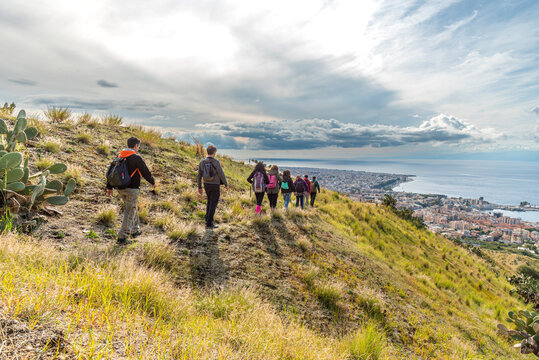 Gruppo di escursionisti in fila indiana su un sentiero in collina