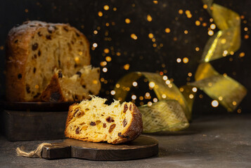 Panettone, Italian Christmas cake with raisins and candied fruits whole and slice on black...