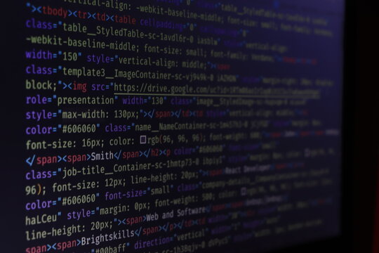 Computer script typing work. Programmer typing new lines of HTML code. Closeup of Java Script, CSS and HTML code. Coding hacker concept. Software source code.