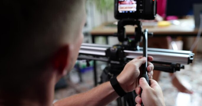Videographer filming tutorial videos for video blog on tripod in office
