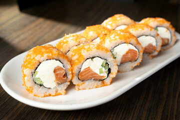 Sushi roll served on white plate in restaurant. japanese traditional food