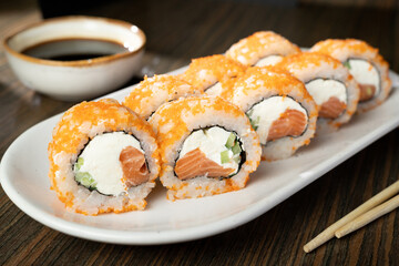 closeup of sushi rolls with chopsticks and soy sauce