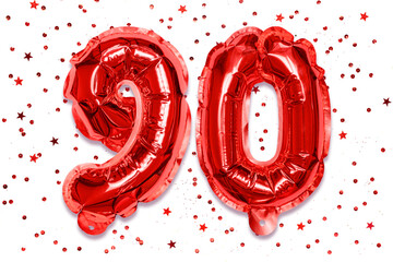The number of the balloon made of red foil, the number ninety on a white background with sequins....
