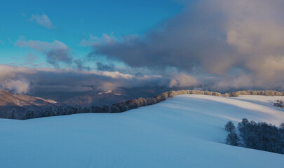 Mountain plateau covered with snow under a cloudy sky. Winter mountain landscape.