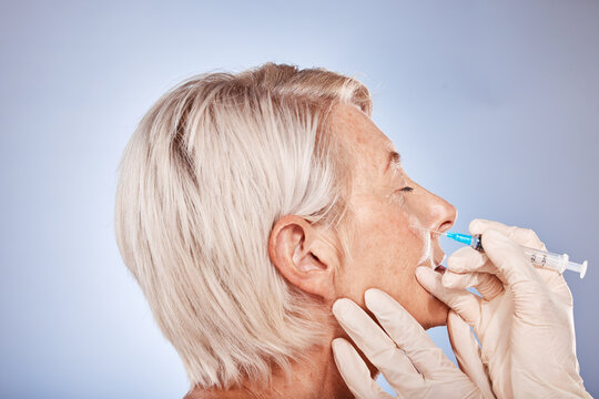 Plastic surgery, senior woman and injection for botox, toned skin and health with grey studio background. Mature female, elderly lady and needle for wellness, to relax facial muscles and anti aging.