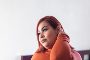 portrait of hispanic overweight woman in profile touching her hair. Mexican plus size model