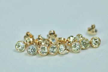 A set of gold-colored buttons with crystals. The concept of hobbies and crafts.