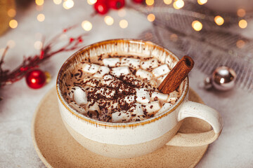 A cup of cocoa with marshmallows on a New Year's table on a white background. Cozy Christmas card