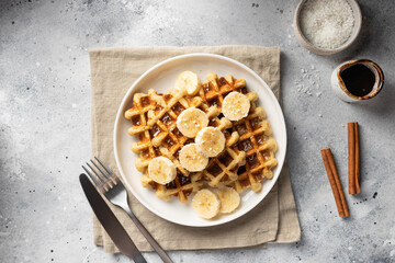 Vegan oatmeal waffles with bananas, cinnamon, coconut and date syrup. table settings. flat lay...
