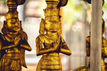 Nahaufnahme von hinduistischen Gottstatuen, die mit Gold bedeckt sind und in hinduistischen Tempeln gefunden wurden