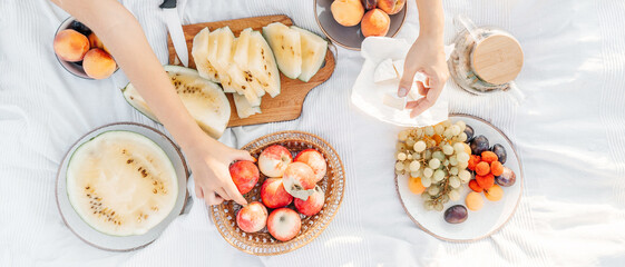 Fruits on white blanket, picnic outdoor. Yellow Watermelon.