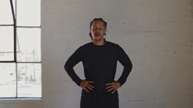 man stands and stretches before workout