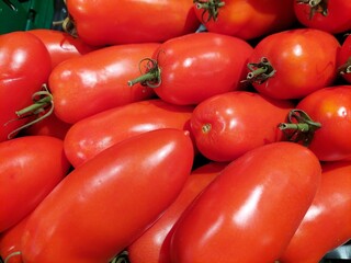 San Marzano tomatoes nicely organized in store rack. This elongated tomato variety originates from Italy where its often used in Italian preparations. It s a delicious fleshy tomato.