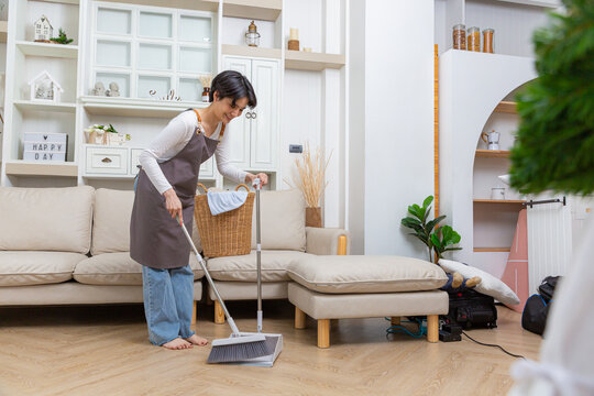 Happy asian woman holding with mop cleaning floor at home. Housekeeping concept