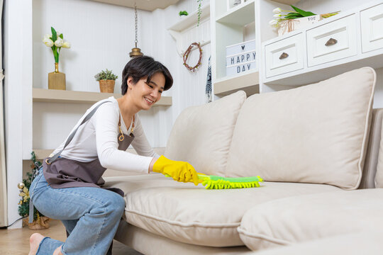 Hygiene and cleanliness in the living room. A Cleaning lady with gloves wipes dust from furniture with a cloth.