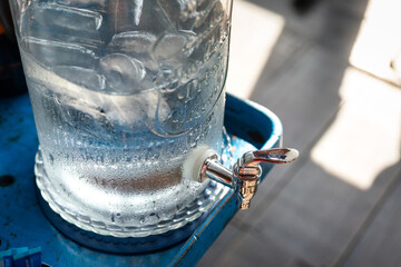 An iced water glass bottle for self service at the breakfast buffet line.  Food and drink object...