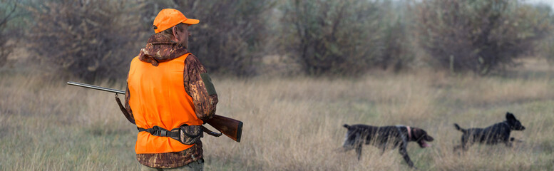Hunter man in camouflage with a gun during the hunt in search of wild birds or game. - obrazy, fototapety, plakaty