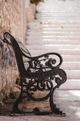 Vertical shot of a black bench in Nafplion, Greece