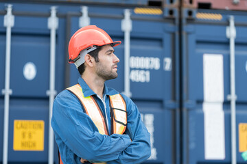 Portrait of male container yard worker working at commercial dock site. Male supervisor container...