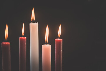 5 candles burning on tradition christian advent wreath, black background