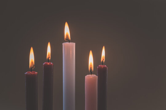 5 candles burning on tradition christian advent wreath, black background