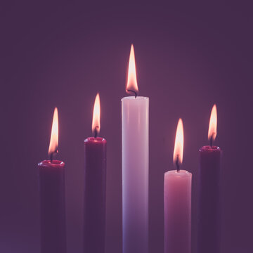 5 candles burning on tradition christian advent wreath, black background