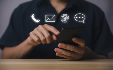Businessman using smartphone showing icon of phone, email, address, live chat. Contact us concept for customer service center connection.