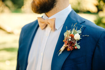 Blue groom suit. Groom with beautiful bow tie and elegant linen suit. Groom with a beard